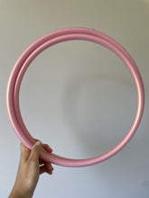 Load image into Gallery viewer, Pink polypro hula hoop held by a hand against a plain background in new zealand