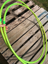 Load image into Gallery viewer, two lime green hula hoops with holographic tape pictured on a pallet