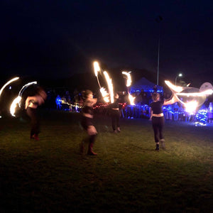 four fire performers with flaming hoops