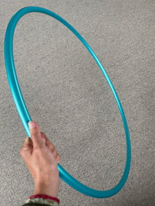 a hand holding a teal hula hoop