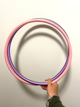 Load image into Gallery viewer, small pink and purple polypro hoop double coiled and held by a hand
