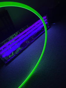 glow in the dark hula hoop glowing under a UV light