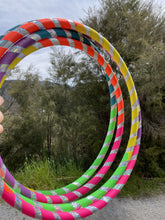 Load image into Gallery viewer, selection of rainbow hula hoops outside
