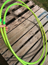 Load image into Gallery viewer, two lime green hula hoops with holographic tape pictured on a pallet 
